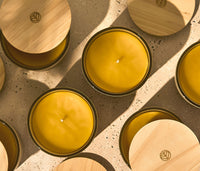 Multiple Branch Basics 100% Beeswax Candles, arranged in a grid with all candles featuring a wooden lid except for the two focal candles, which showcase the candle's beeswax. - Thumbnail View 4
