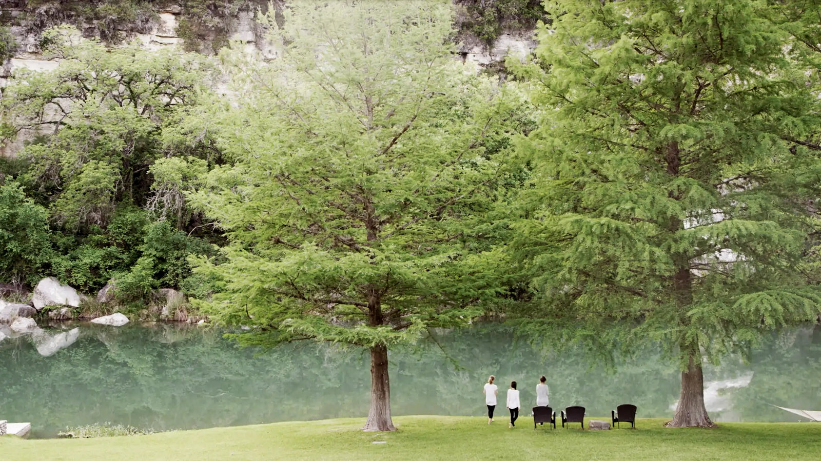 Allison, Kelly, and Marilee walking along a path by a lake with trees in the background