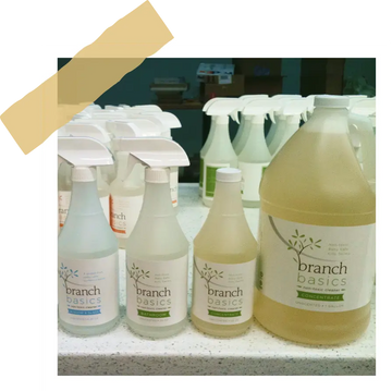 Branch Basics cleaning products on a shelf; image contained within a frame to emulate the look of a polaroid.
